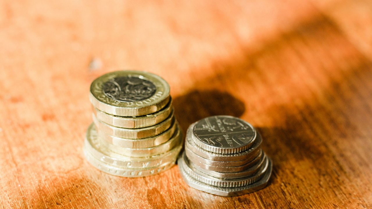 木の机に置かれた、高さの違う2つの硬貨の山