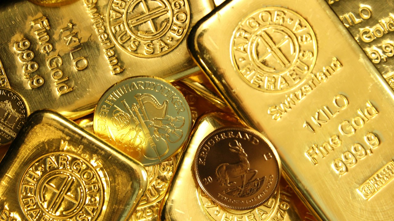 積み重なった金の延べ棒と金貨